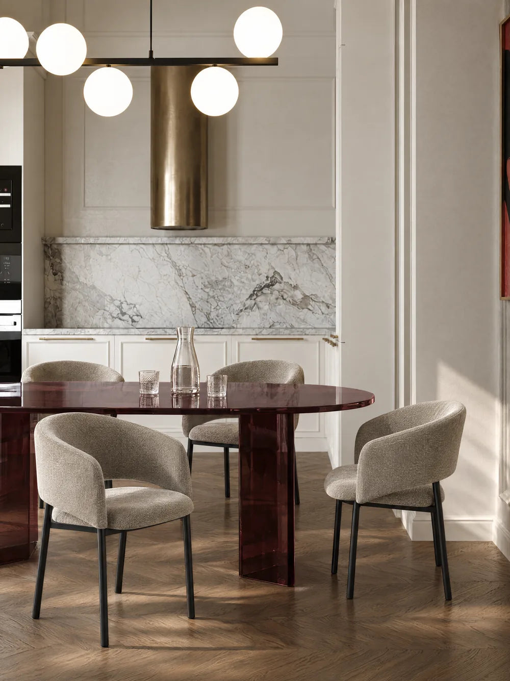 Table ovale et chaises claires devant une cuisine en marbre