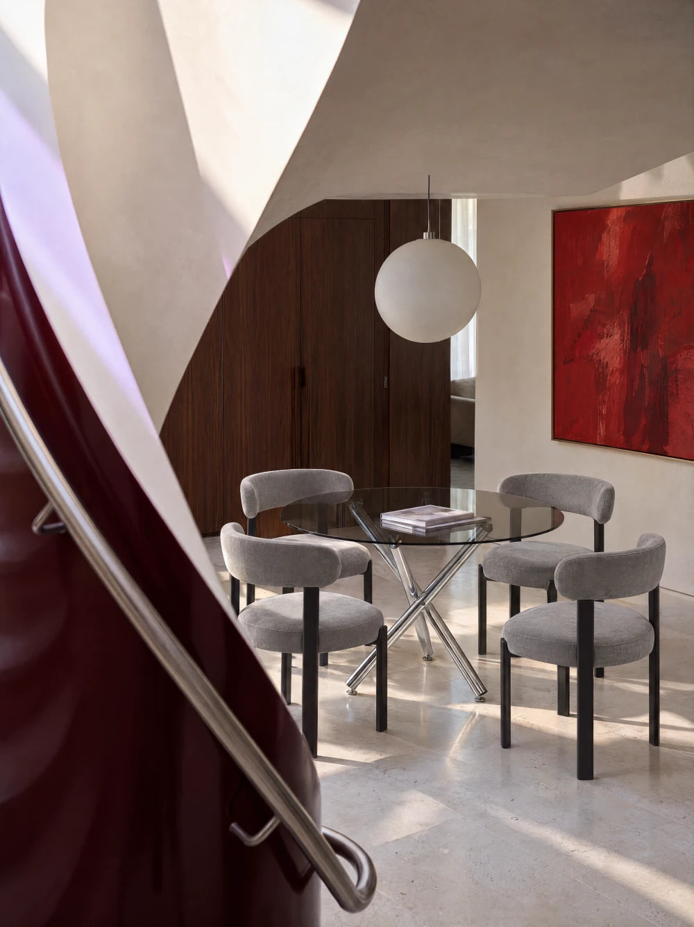 Table en verre et chaises grises près d'un escalier