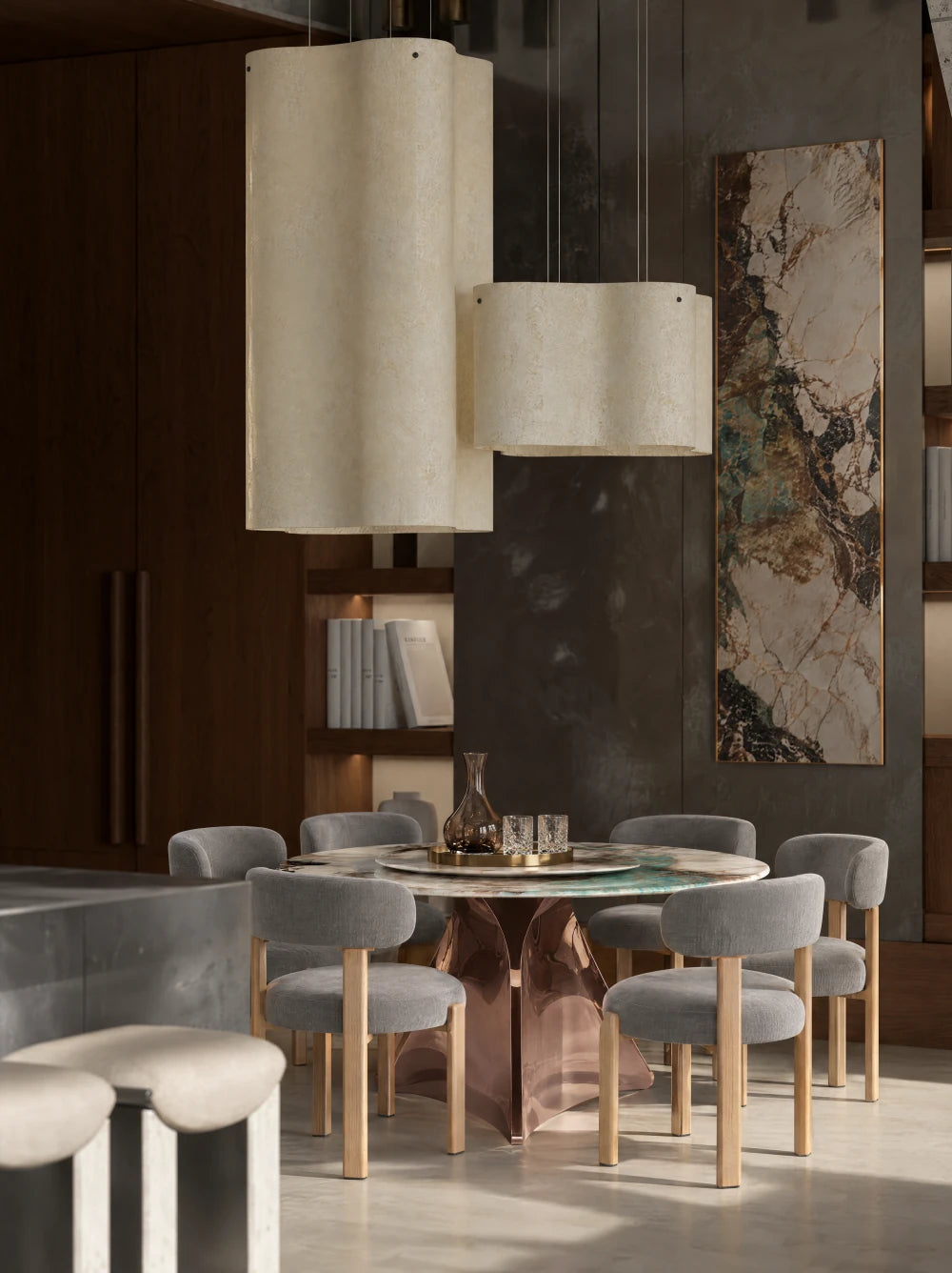 Table ronde et chaises grises sous de grandes suspensions